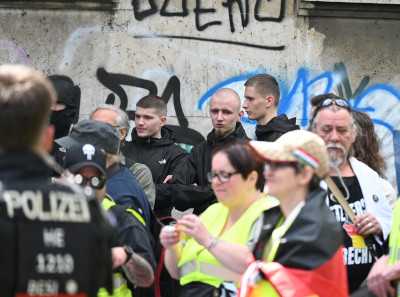 Im Hintergrund: "Jung und Stark" Hessen bei einem Aufmarsch am 26. April 2025 in Frankfurt.